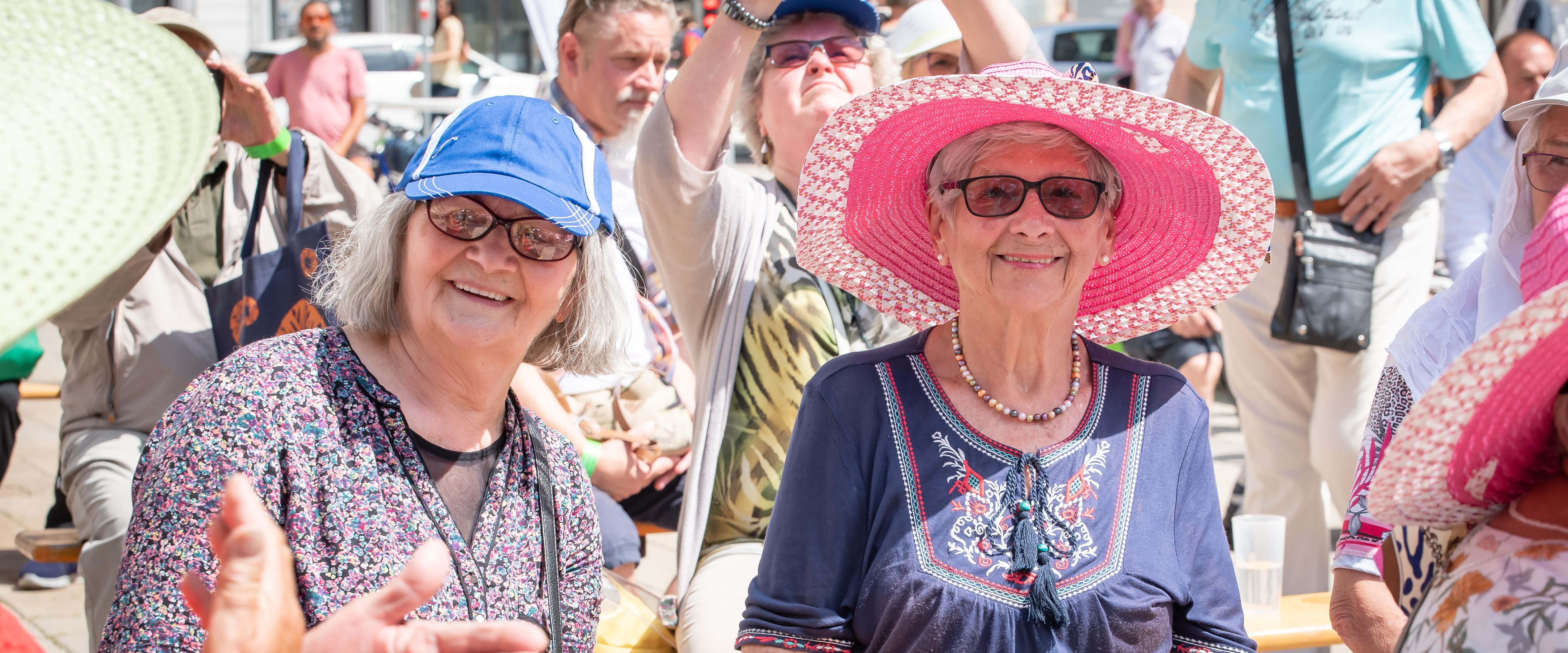 Seniorinnen mit Sonnenhut und Sonnenbrillen beim Sommerfest