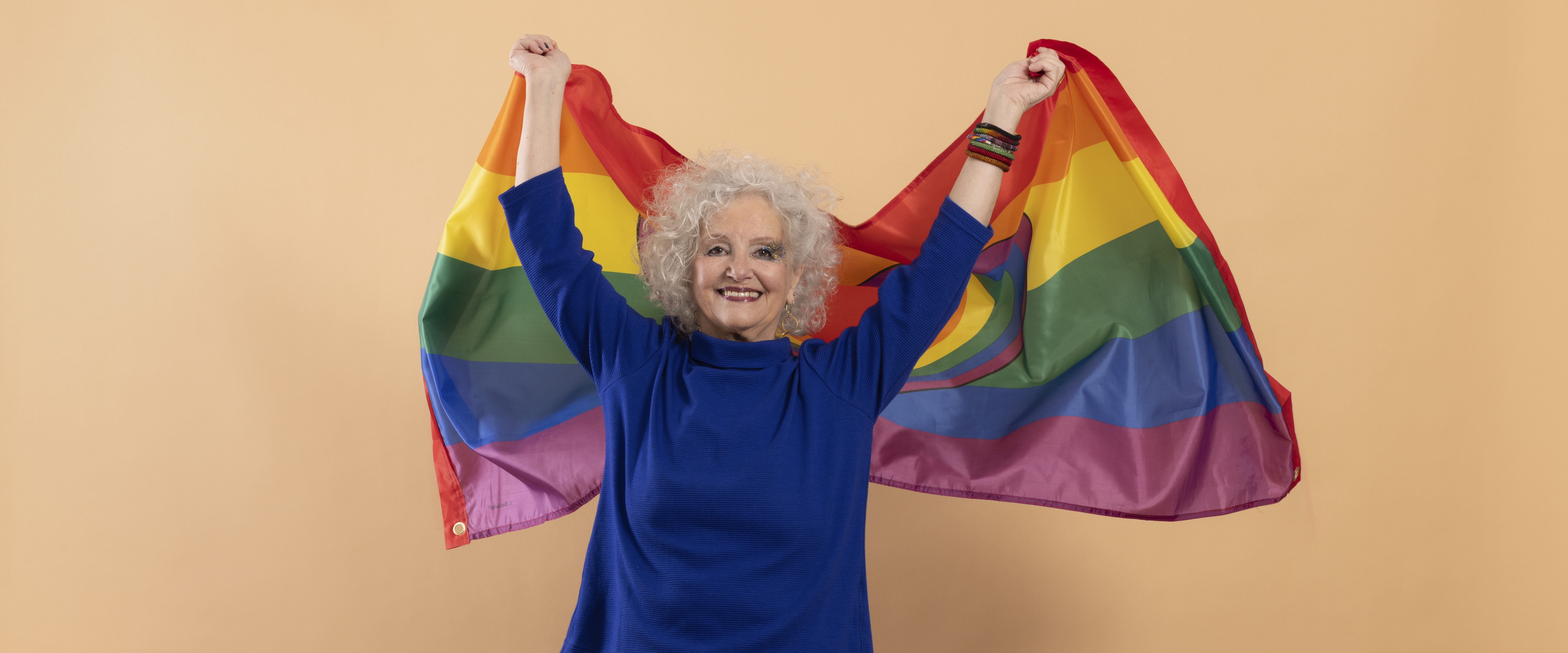 Seniorin hält Regenbogen-Flagge