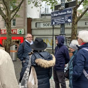 Eine Gruppe von Personen steht während eines Stadtspaziergangs in Wien-Margareten vor einem Straßenschild.