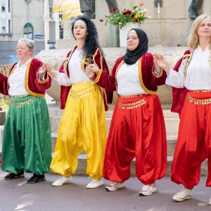 Frauen in bosnischer Tracht tanzen gemeinsam.