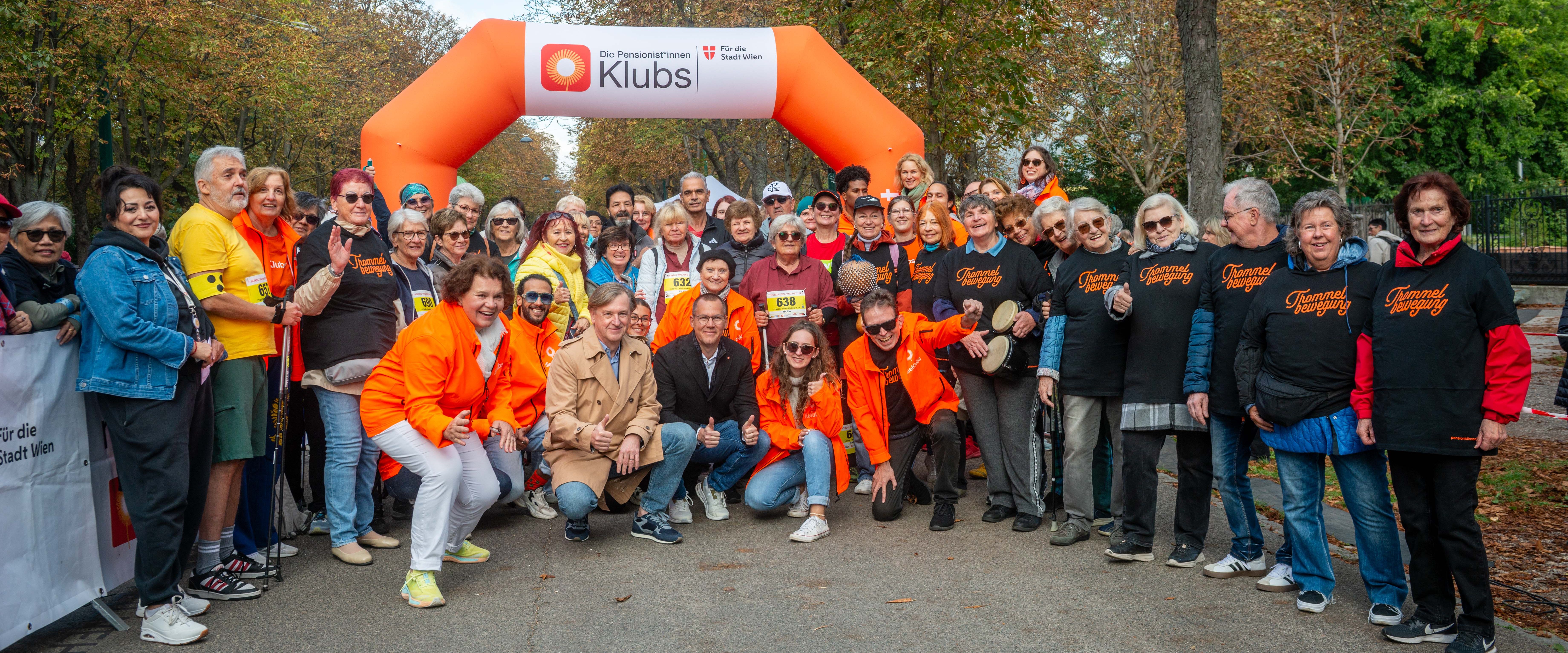 Senior*innen uns Ehrengäste posieren an der Startlinie des Nordic Walking Day 2025.