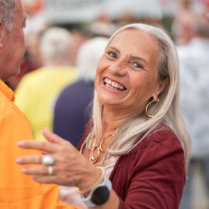 Tanzendes Paar. Seniorin lächelt in die Kamera.
