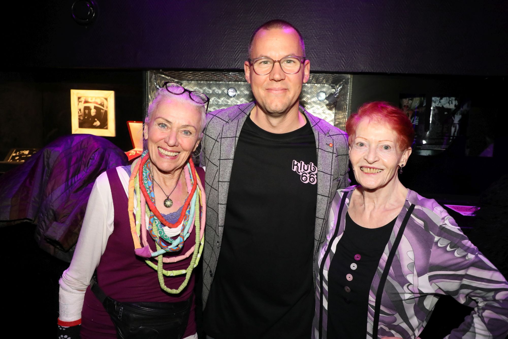 66er Klub im U4 am 06.11.2025 - © Conny de Beauclair zwei Damen lächeln in die Kamera, und zwischen ihnen steht Simon Bluma, der stellvertretende Geschäftsführer der Häuser zum Leben.