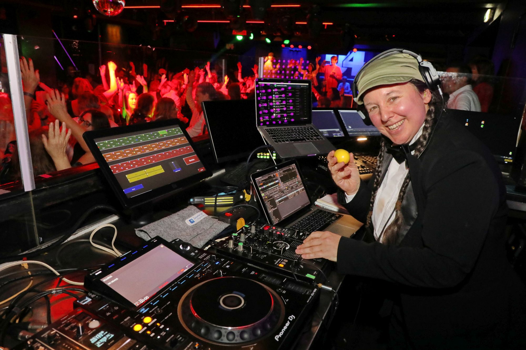 66er Klub im U4 am 06.11.2025 - © Conny de Beauclair Die DJ steht vor dem DJ-Pult und lächelt vor der tanzenden Menge in die Kamera.