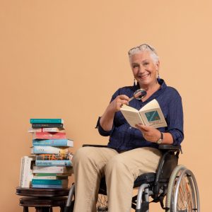 Frau in Rollstuhl hält Buch in der Hand