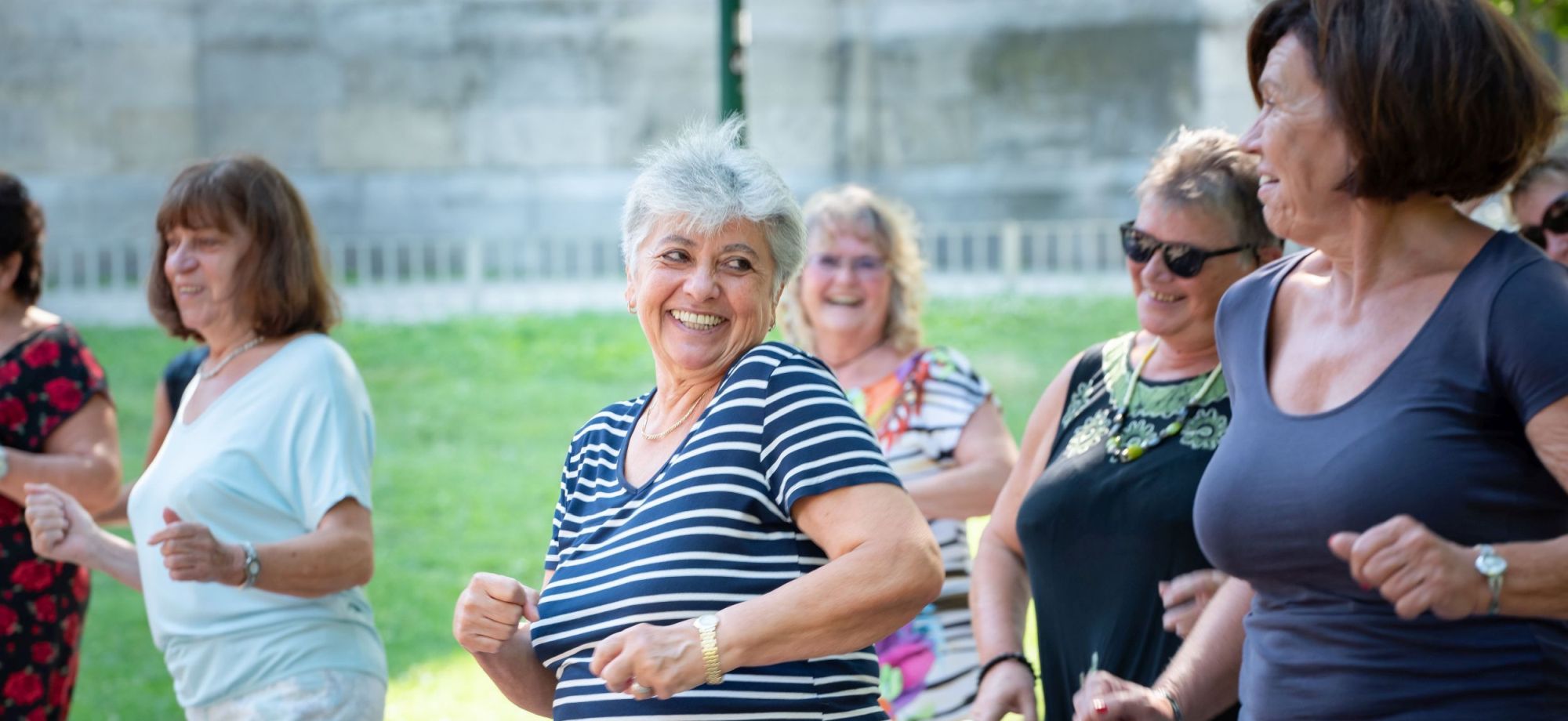 Seniorinnen tanzen im Freien.