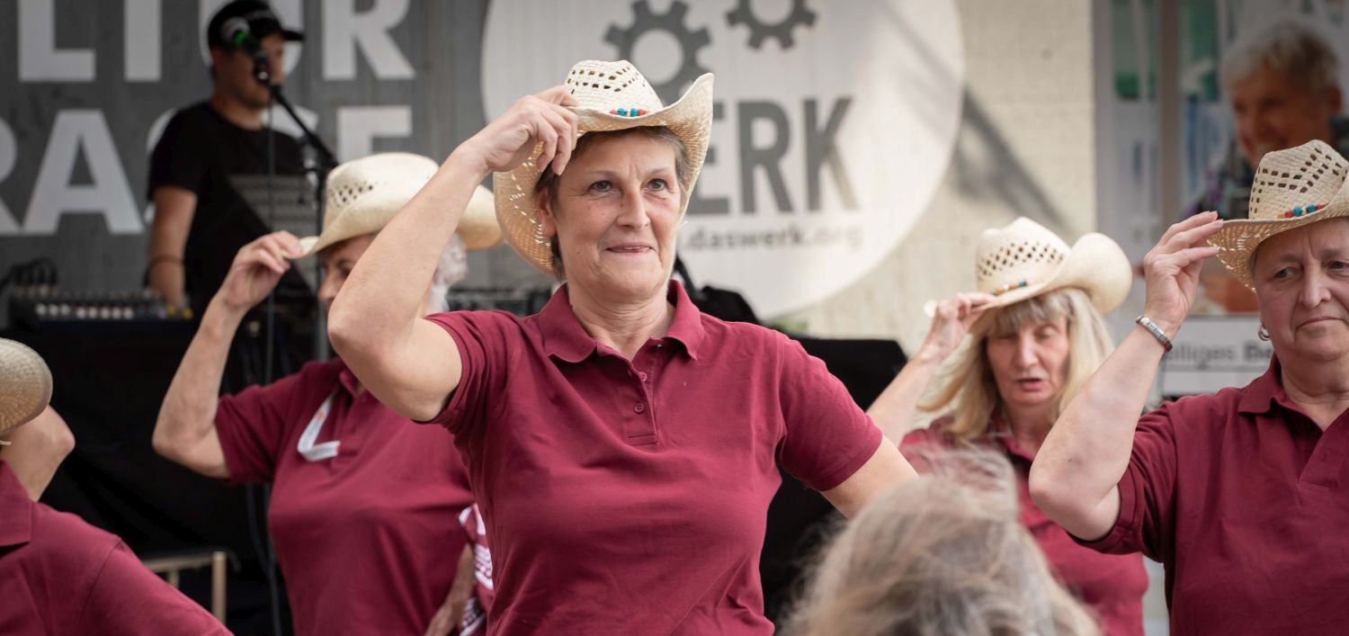 Mehrere Frauen mit Cowboy-Hüten beim Line Dance