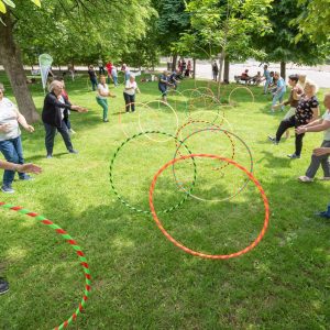 Frauen rollen sich in einem Park Hula-Hoop-Reifen zu.