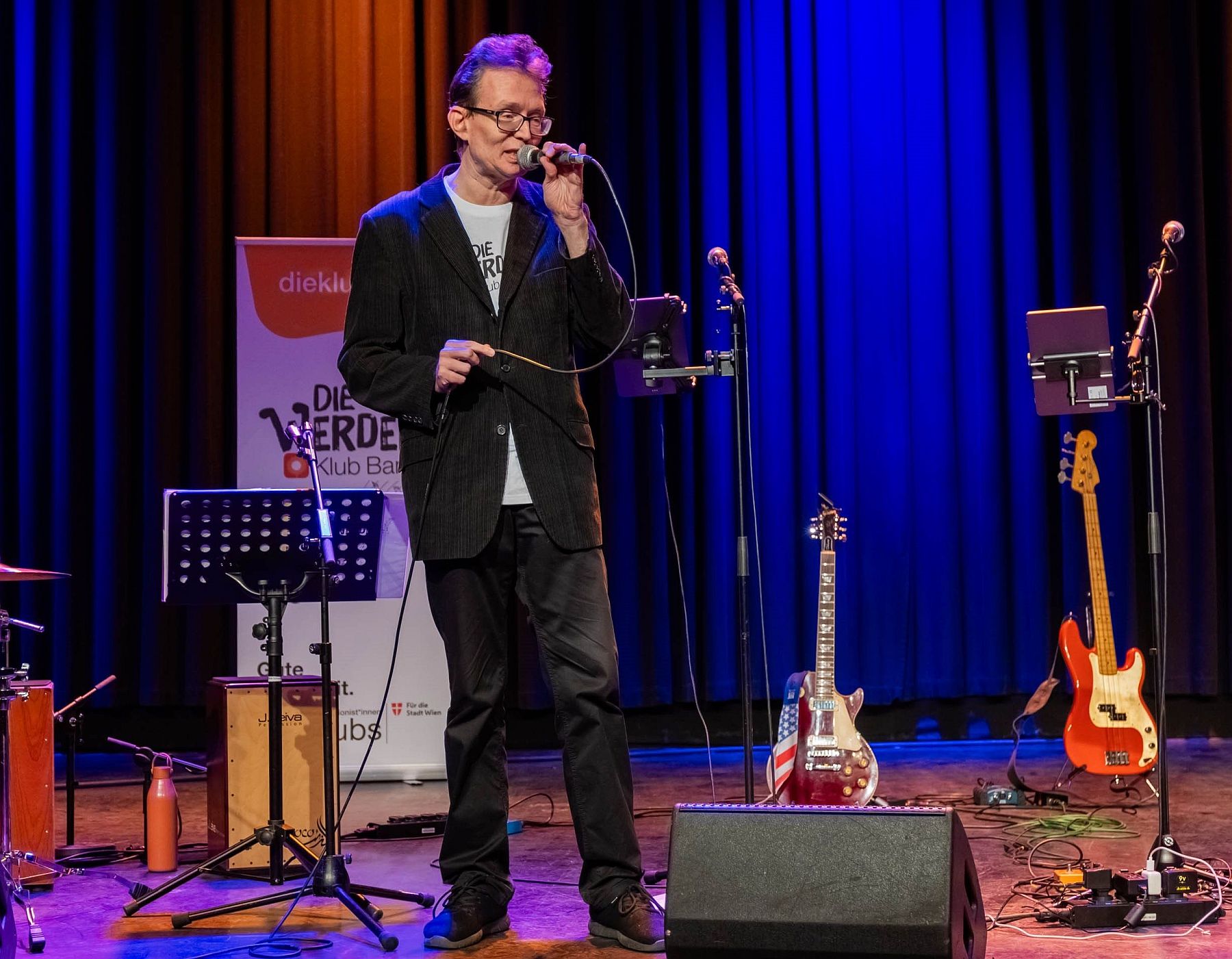 werder_christian klein Christian Klein von der Werder Klub Band steht auf der Bühne und hält ein Mikrofon.