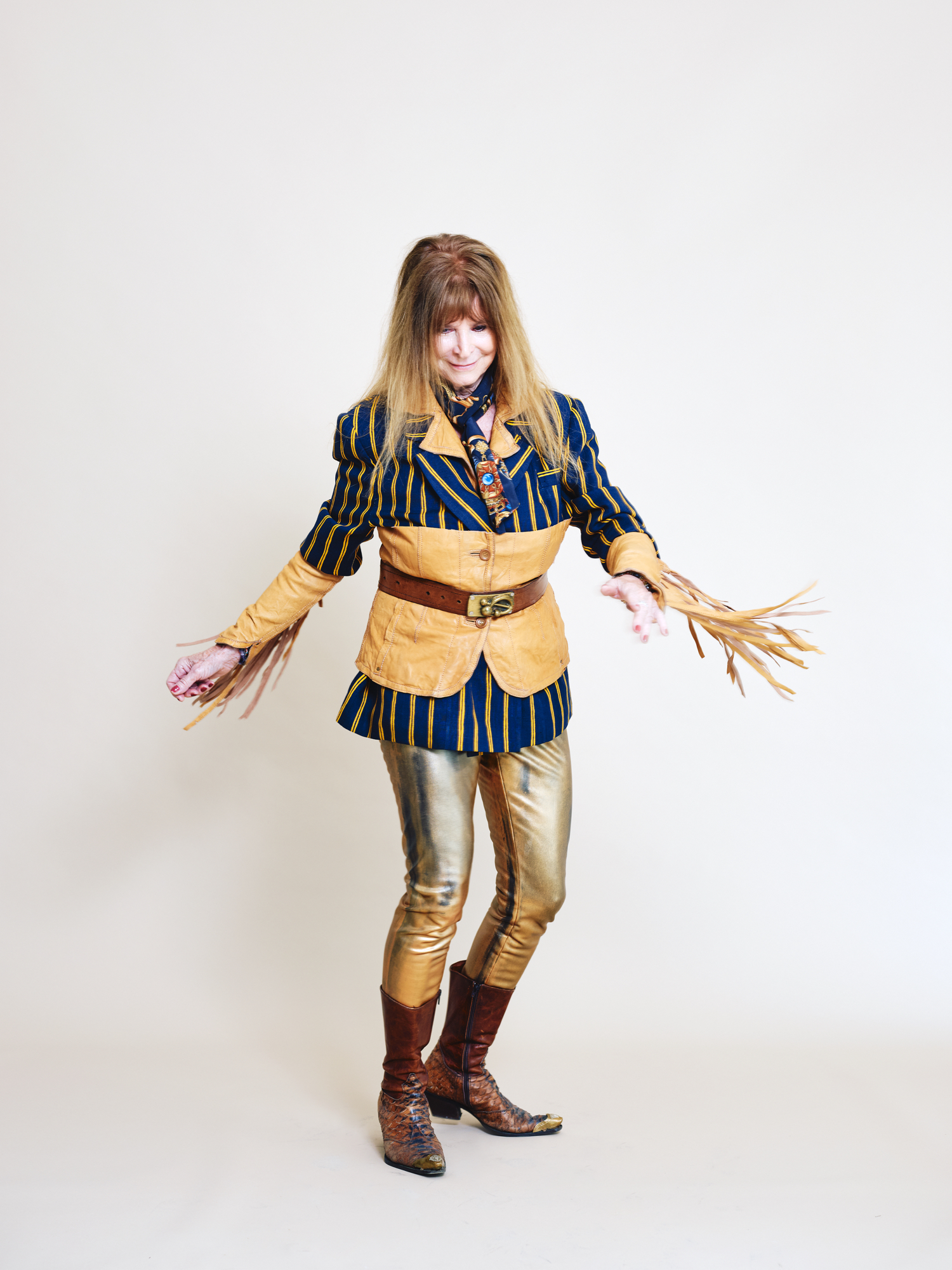 Ein weibliches Model in ihrem selbst designten Gewand (Blazer mit Gürtel und enge goldene Hose) für die Vienna Fashion Week 2026.