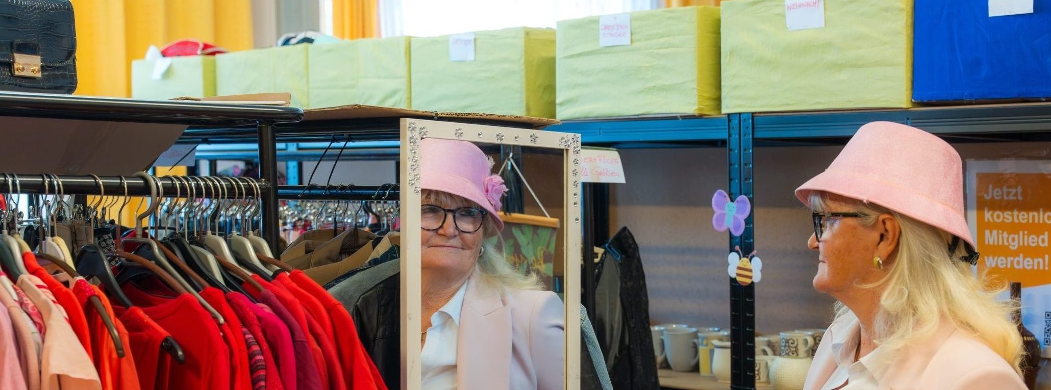 Eine Frau mit Hut sieht sich in den Spiegel.