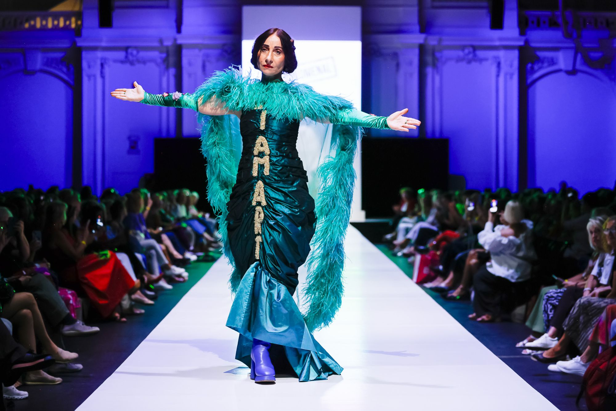 Vienna Fashion Week 2026 Ein Model mit türkisem Kleid auf dem Laufsteg der Vienna Fashion Week 2026.