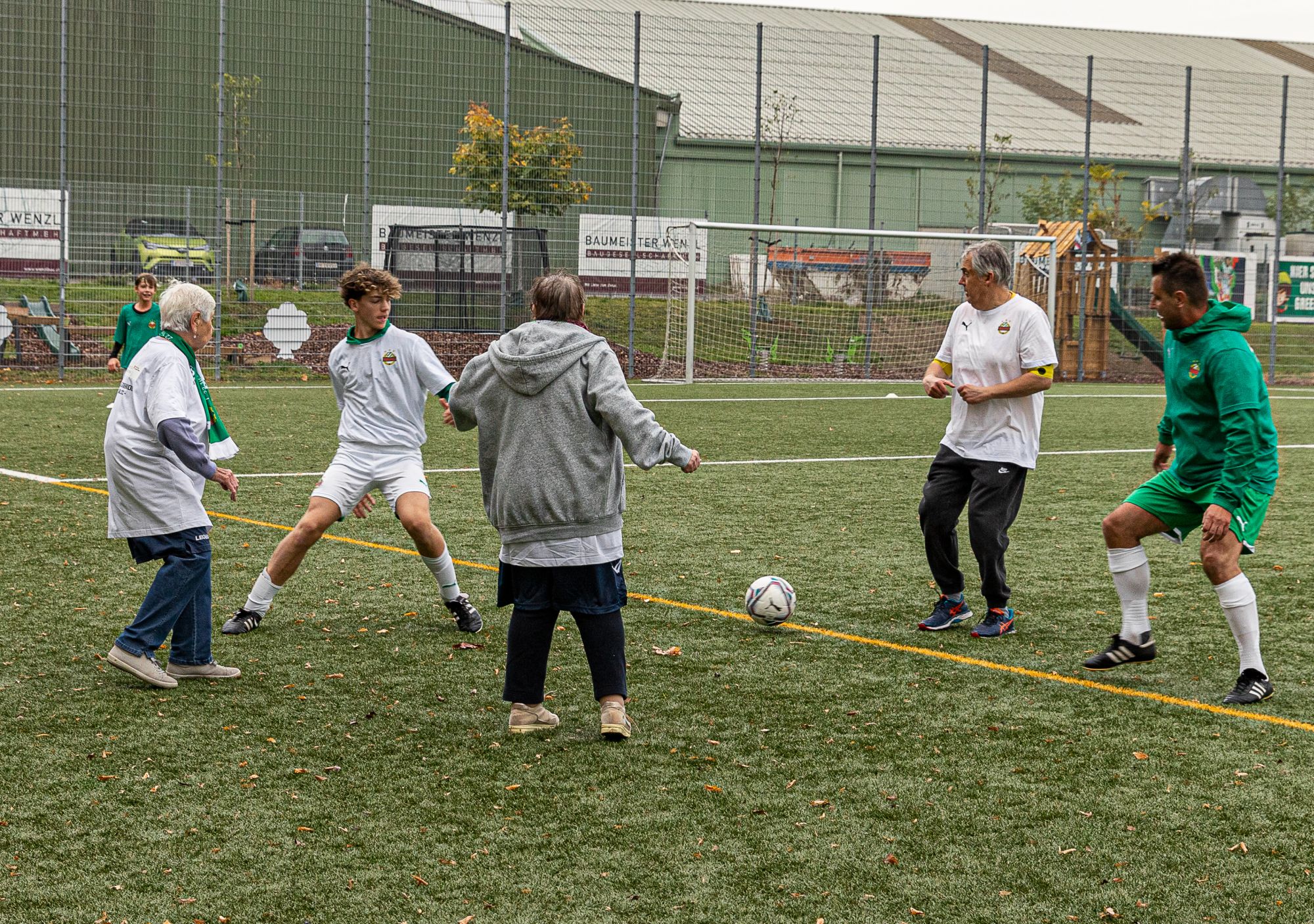 Personen unterschiedlichen Alters spielen Fußball