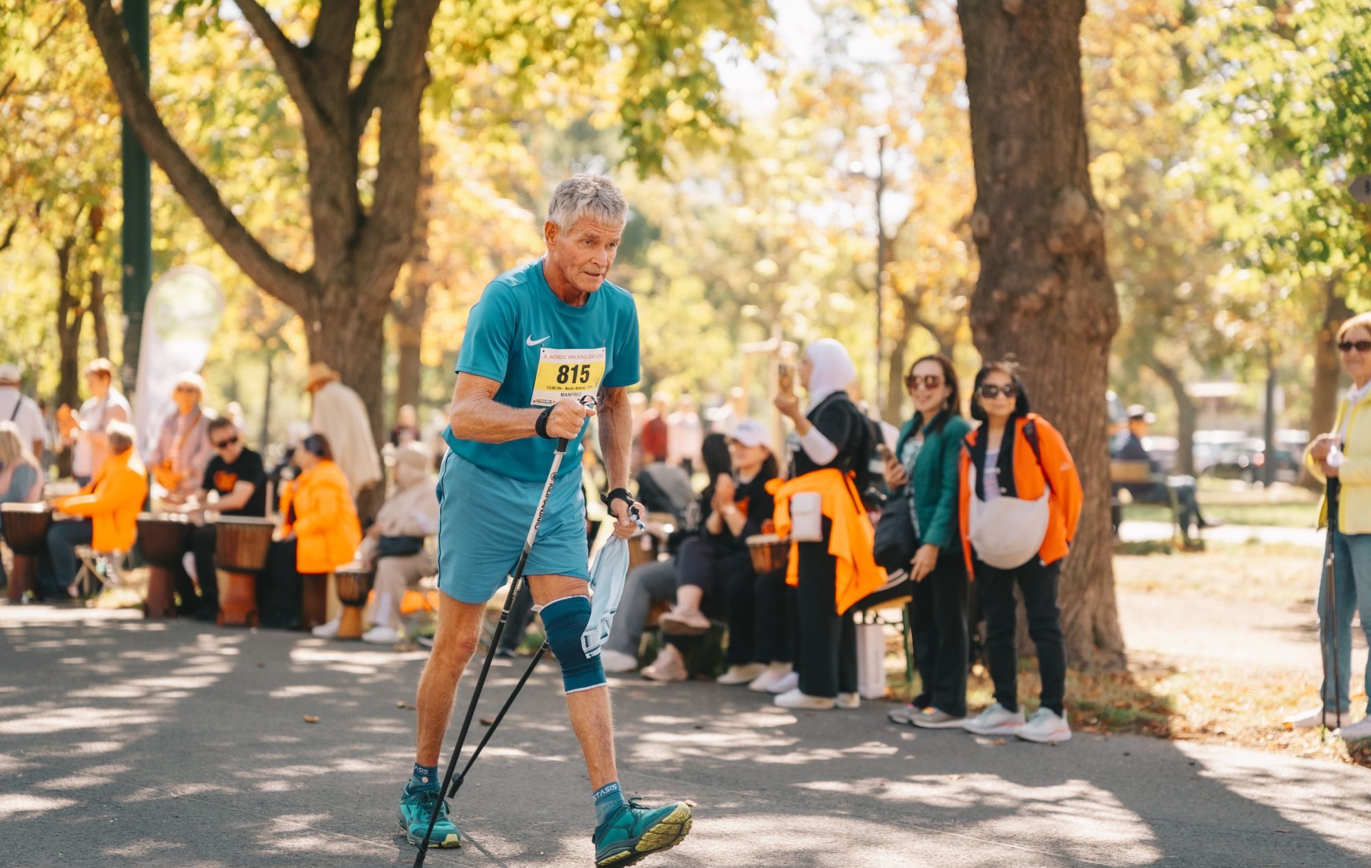 Ein älterer Mann geht beim Nordic Walking Day 2026 im Wiener Prater, im Hintergrund Zuschauer*innen.