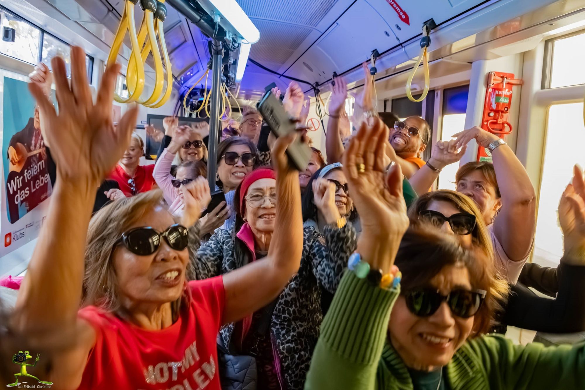 Mehrere Menschen lachen und halten die Hände in die Höhe in der Disco-Straßenbahn der Pensionist*innenklubs.