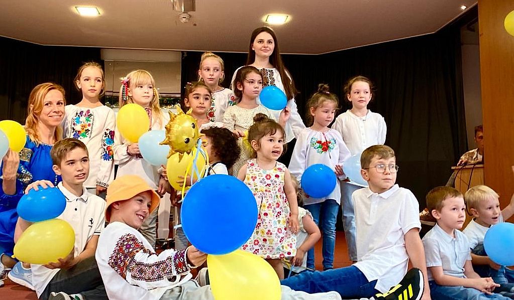 Aus der Ukraine geflohene Kinder mit gelben und blauen Luftballons bei einem Fest im Haus Mariahilf
