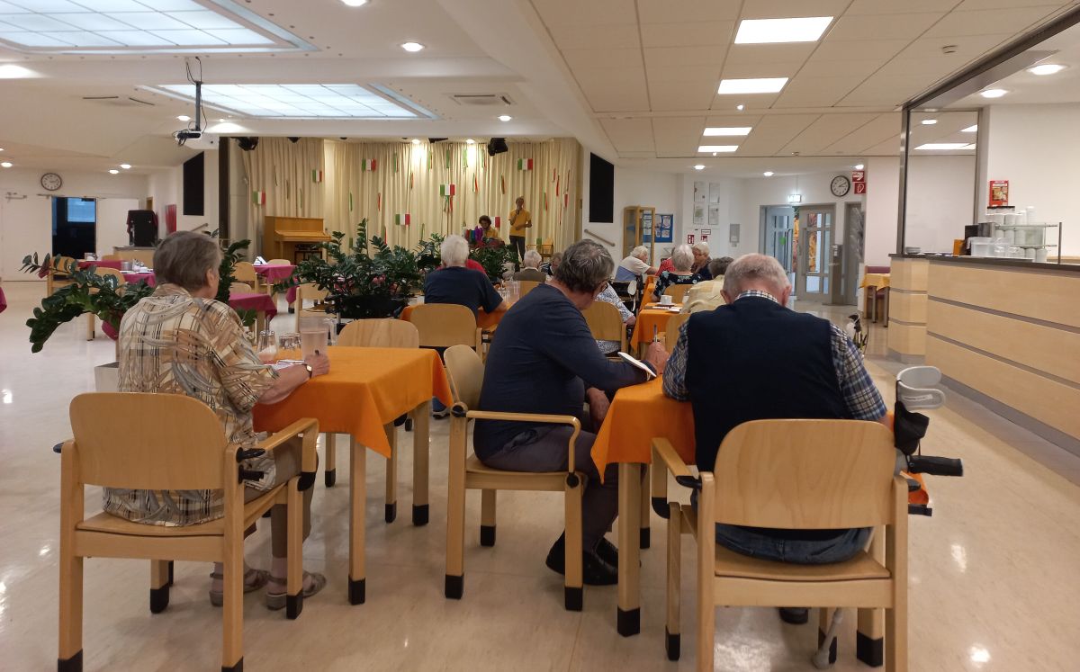 Saal mit Bingo spielenden BewohnerInnen des Pensionisten-Wohnhauses Rossau