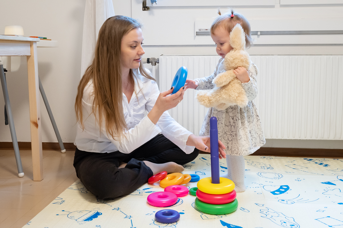 Eine junge Frau spielt mit einem kleinen Mädchen.