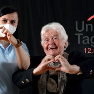 Pflegerin mit Seniorin formen mit Hand ein Herz