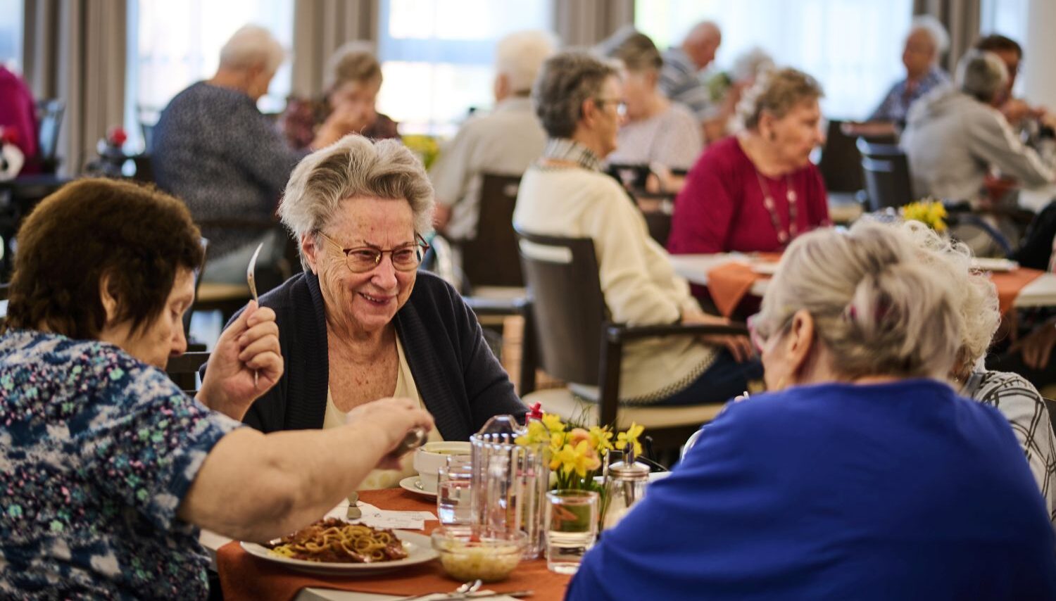 Seniorinnen beim Mittagessen an einem Tisch im Speisesaal
