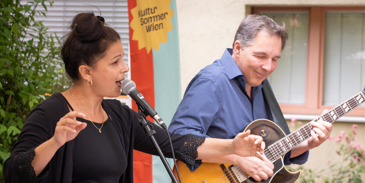 Eine Sängerin und ein Gitarirst beim Kultursommer-Konzert im Garten des Hauses Maria Jacobi