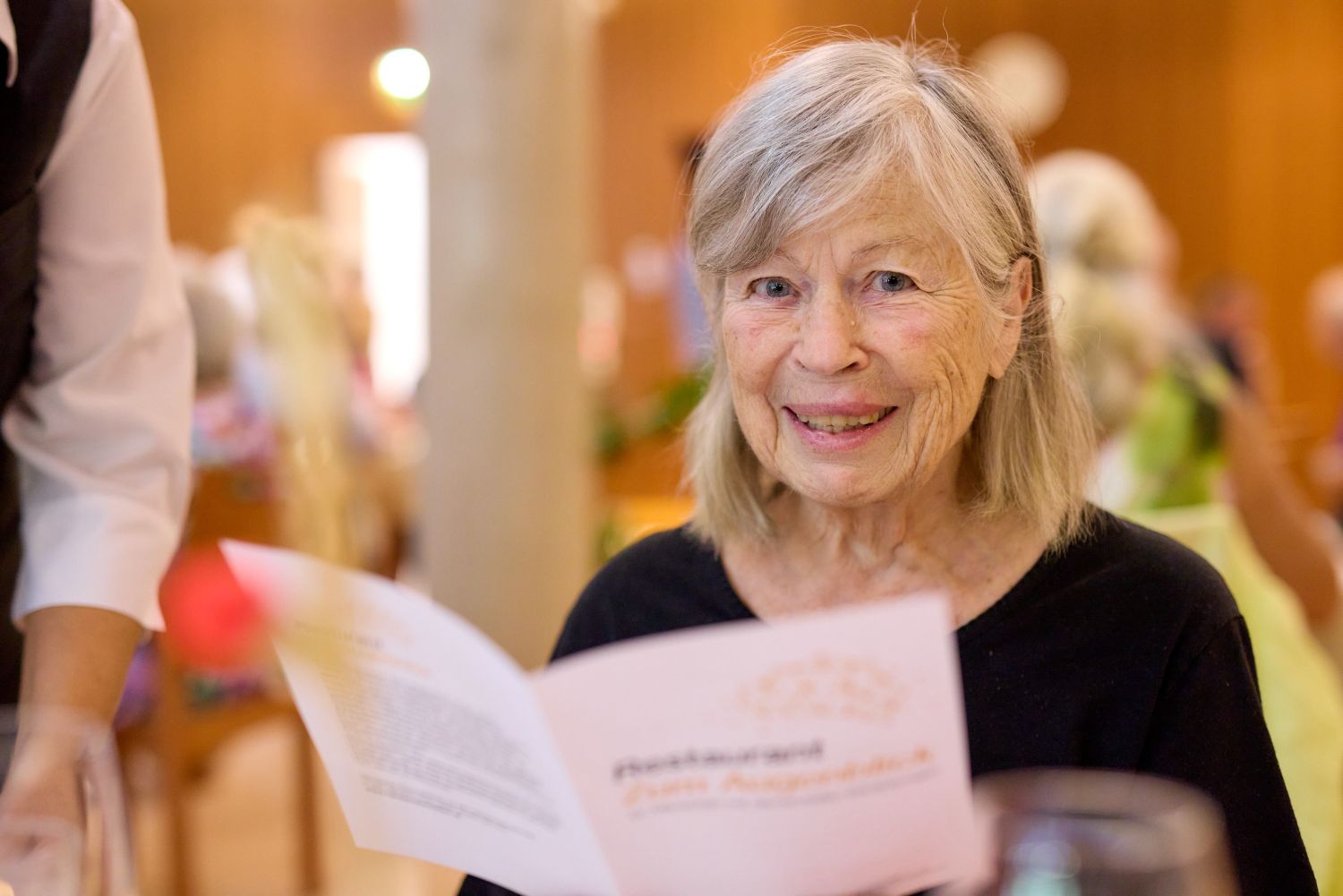 Eine Seniorin liest die Menükarte im Demenz-Restaurant "Zum Augenblick".
