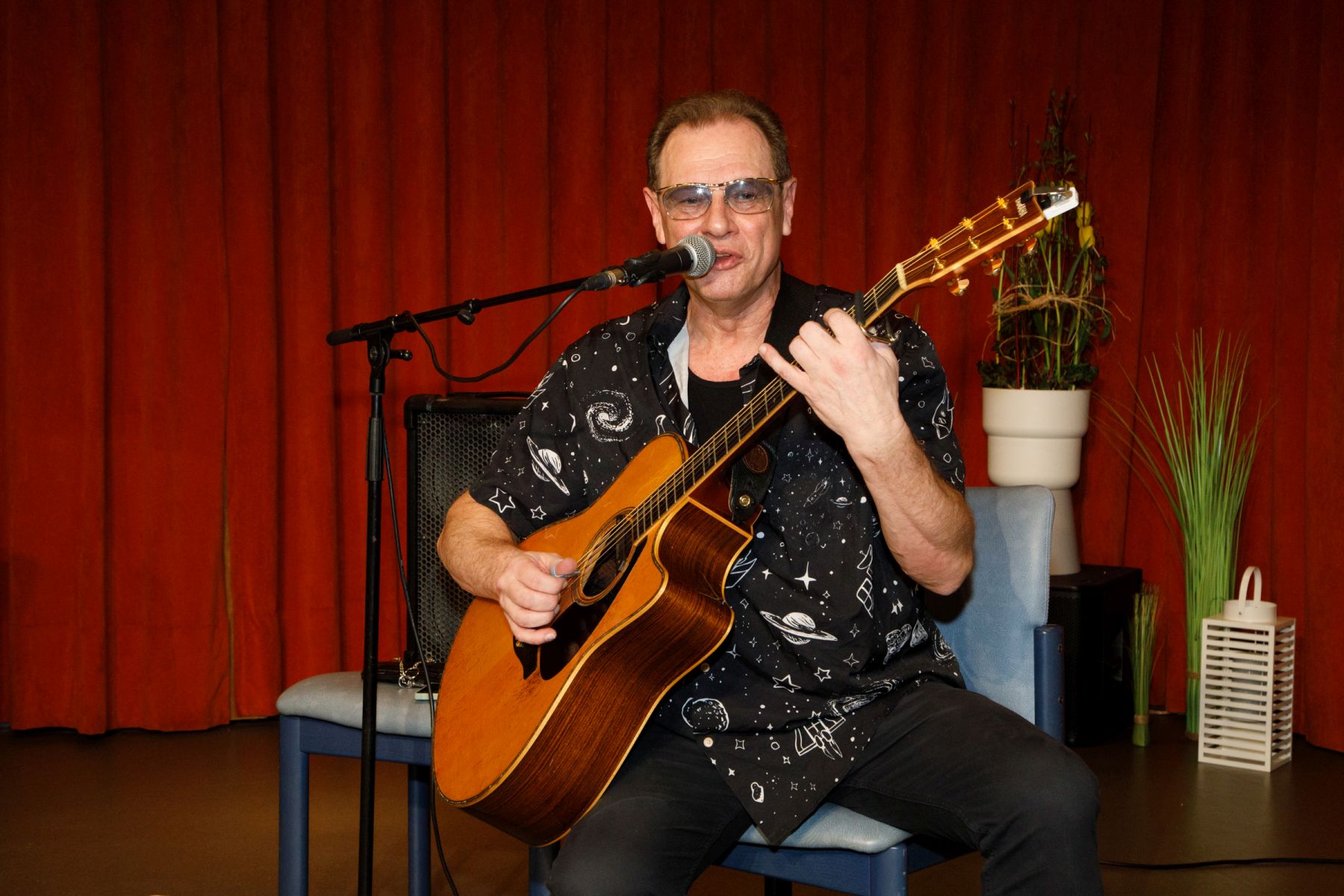 Ein Musiker mit einer Gitarre auf der Bühne im Haus Wieden.
