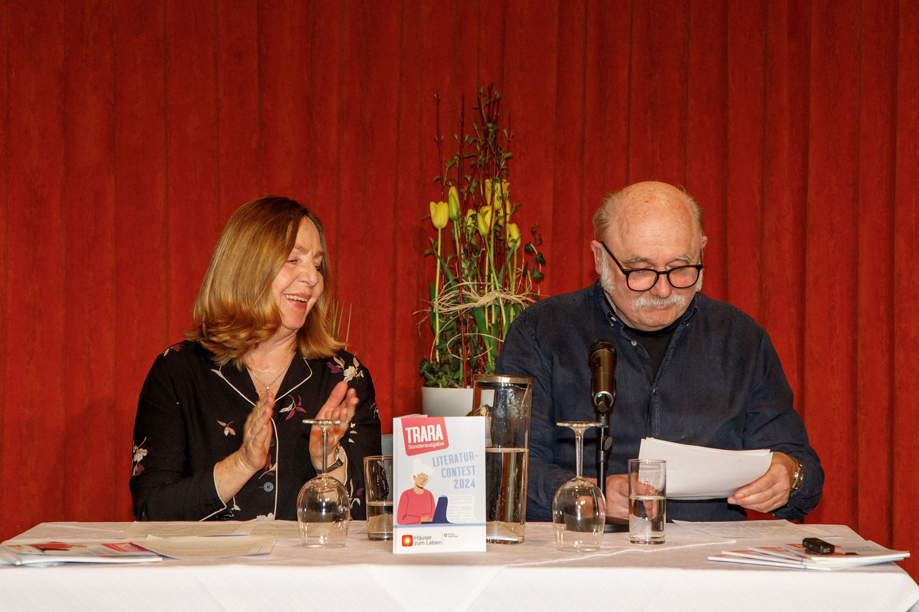 Susi Stach und Karl Fischer sitzen hinter einem Tisch.
