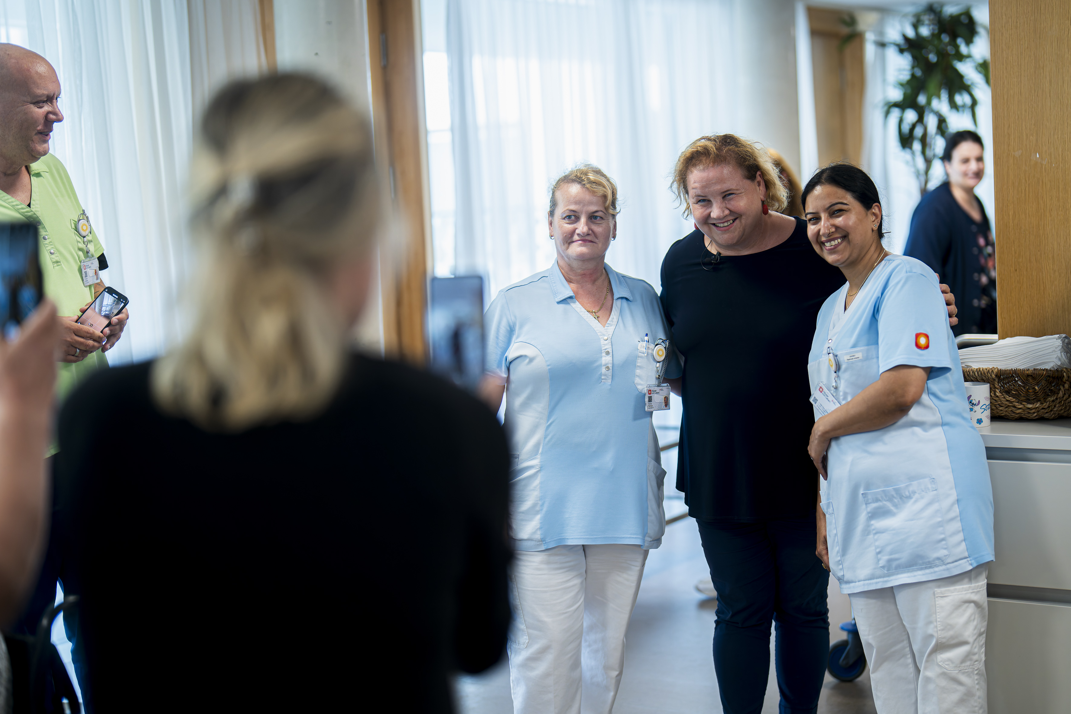 Bundesministerin Korinna Schumann posiert mit zwei Mitarbeiter*innen im Haus Penzing für ein Foto.