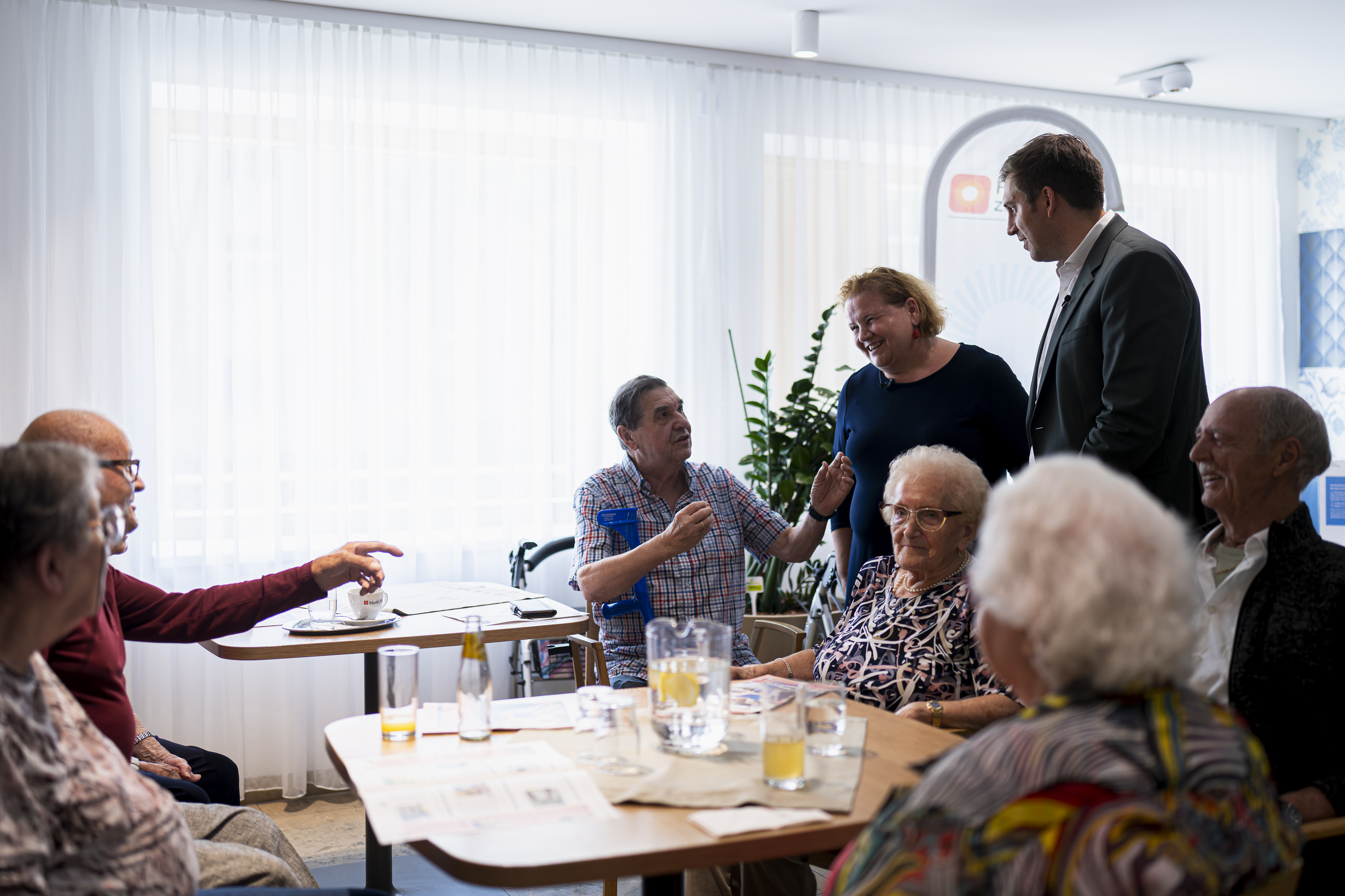 Bundesministerin Korinna Schumann und Staatssekretär Alexander Pröll sprechen mit Senior*innen im Haus Penzing.
