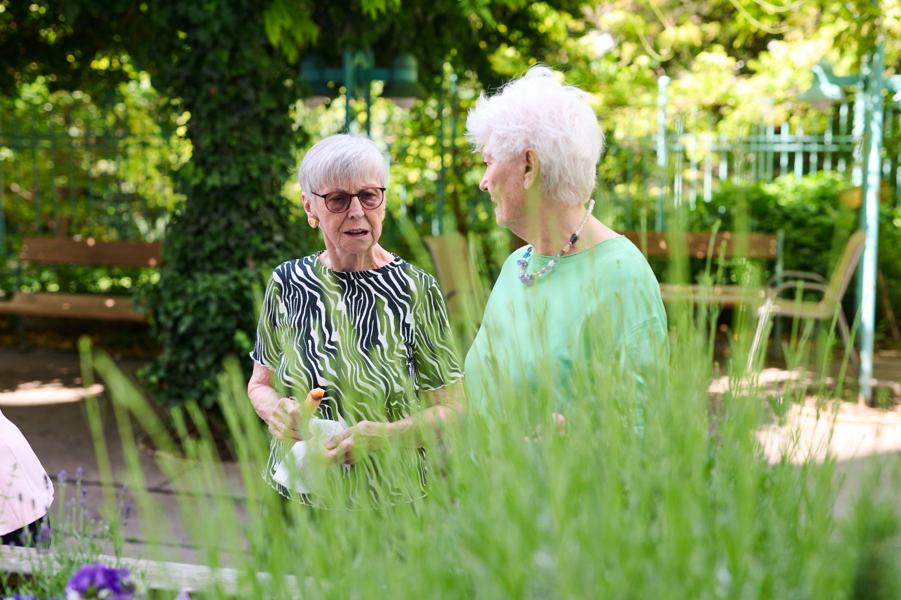 Zwei ältere Frauen stehen im Garten des Pensionisten-Wohnhauses Gustav Klimt in Wien-Penzing.