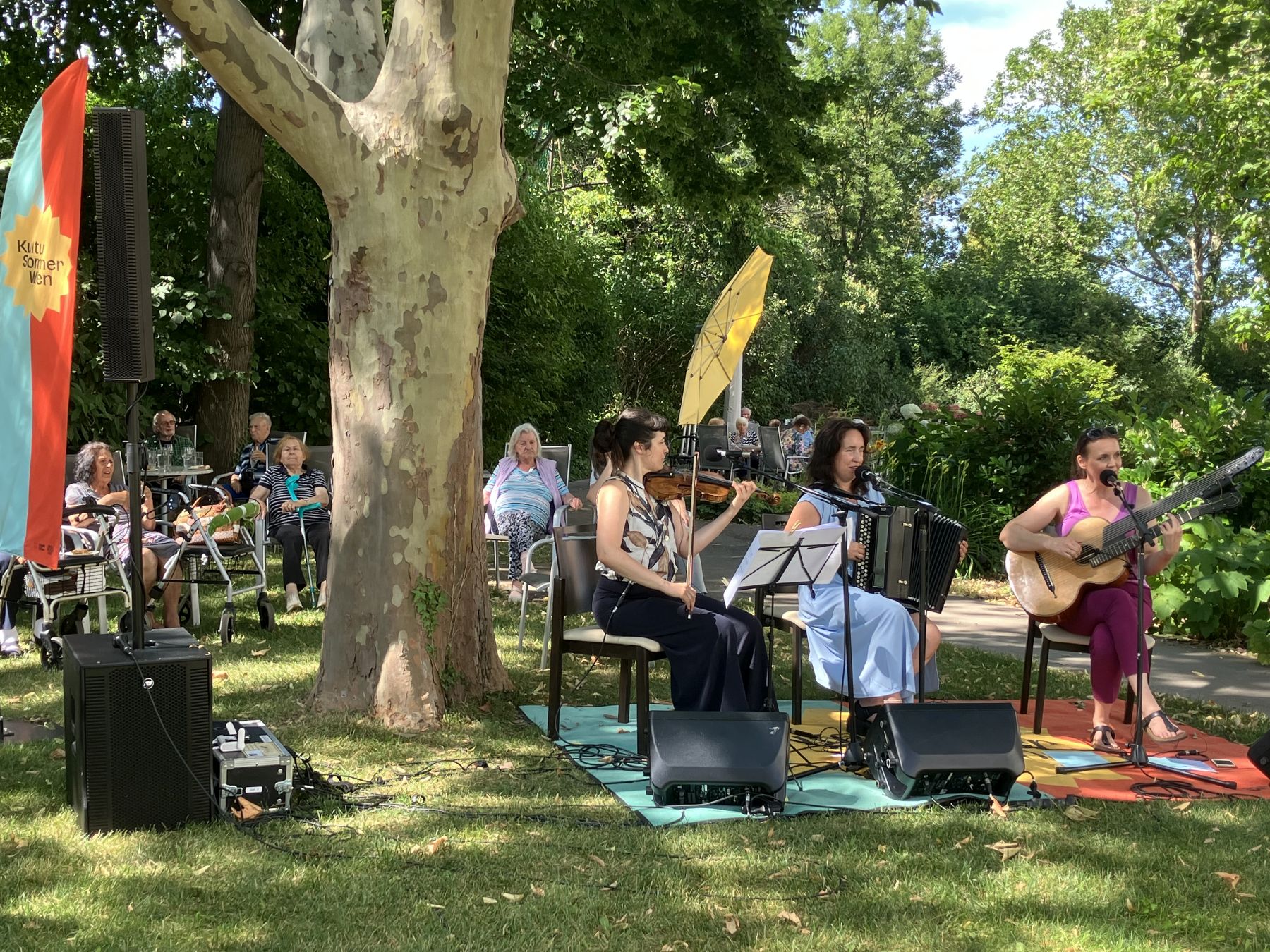 Drei Musikerinnen mit Instrumenten beim Gartenkonzert im Garten des Hauses Schmelz.
