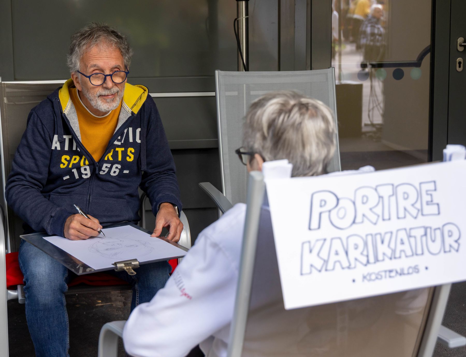 Ein Karikaturist zeichnet eine Seniorin.