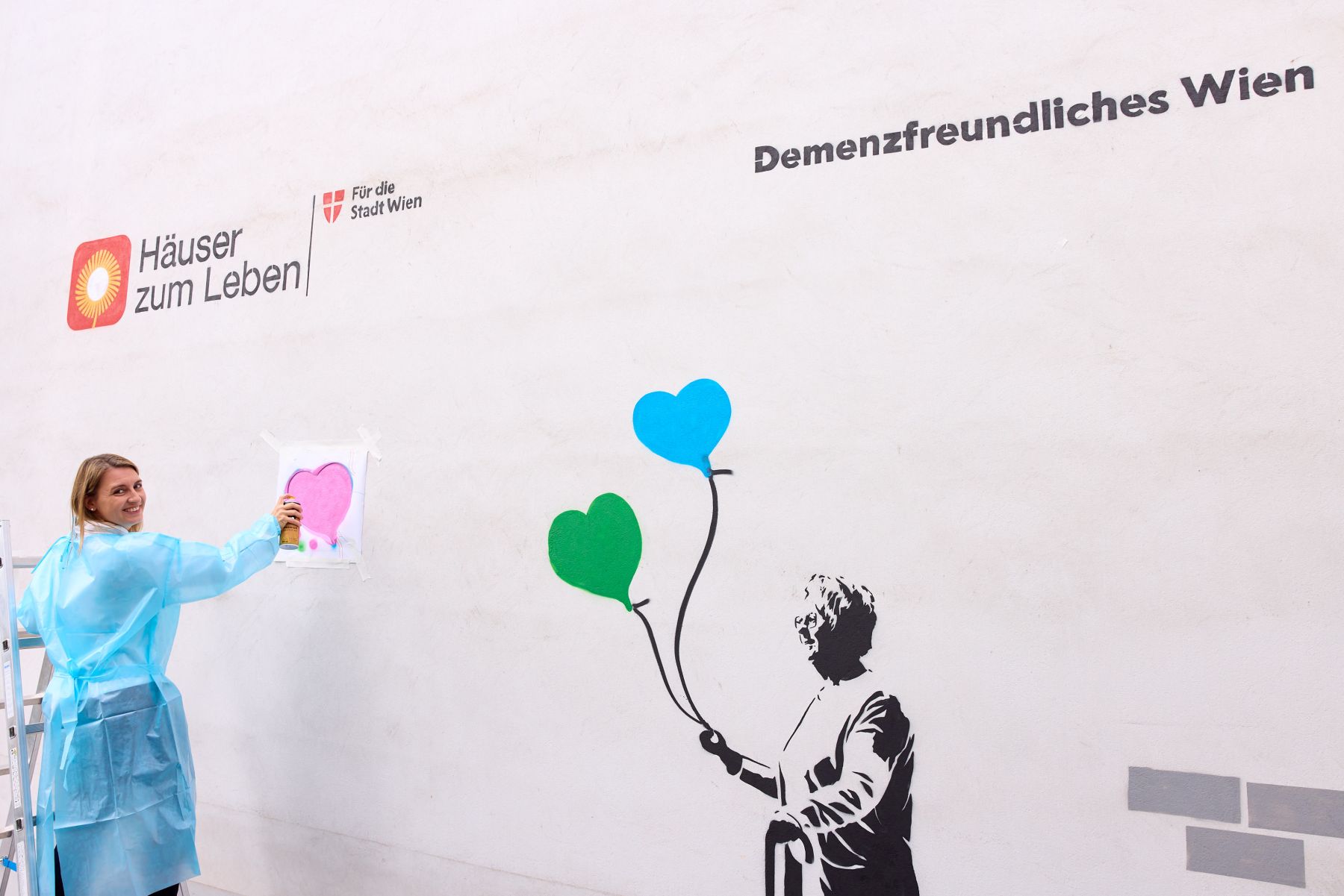 Hietzings Bezirksvorsteherin Johanna Zinkl sprüht ein rosa Herz an die Wand.
