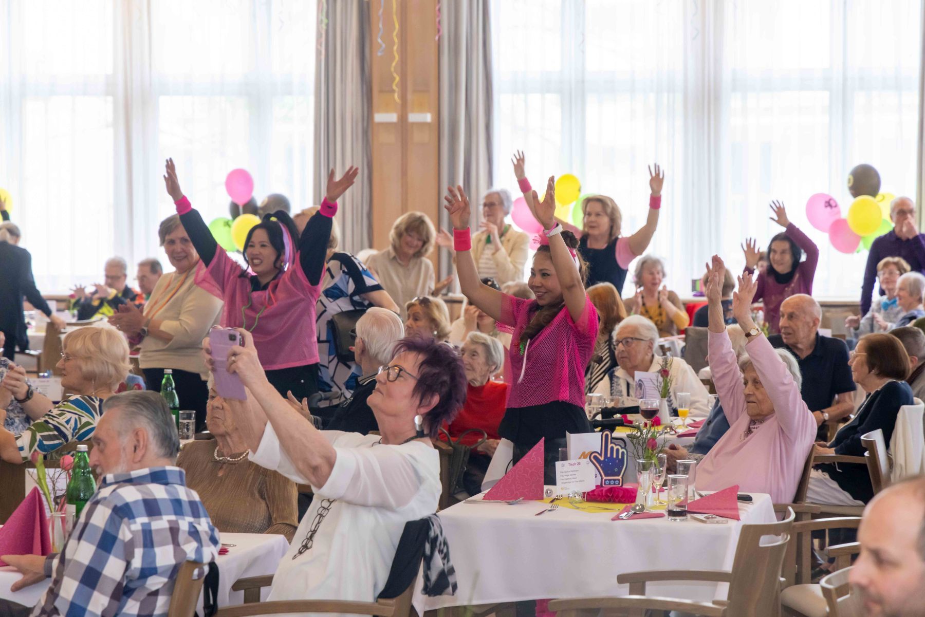 Feier 40 Jahre Trazerberg, Häuser zum Lebern Personen im Publikum bei der 40-Jahr-Feier des Pensionisten-Wohnhauses Trazerberg halten die Hände in die Höhe.