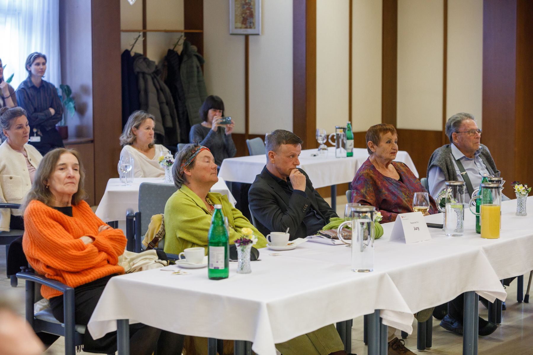 Fünf Personen sitzen an einem Tisch mit dem Schild "Jury". Vier Jurymitglieder (von links): Patricia Brooks, Ilse Kilic, Kornelius Taxenbach, Ingrid Mahl