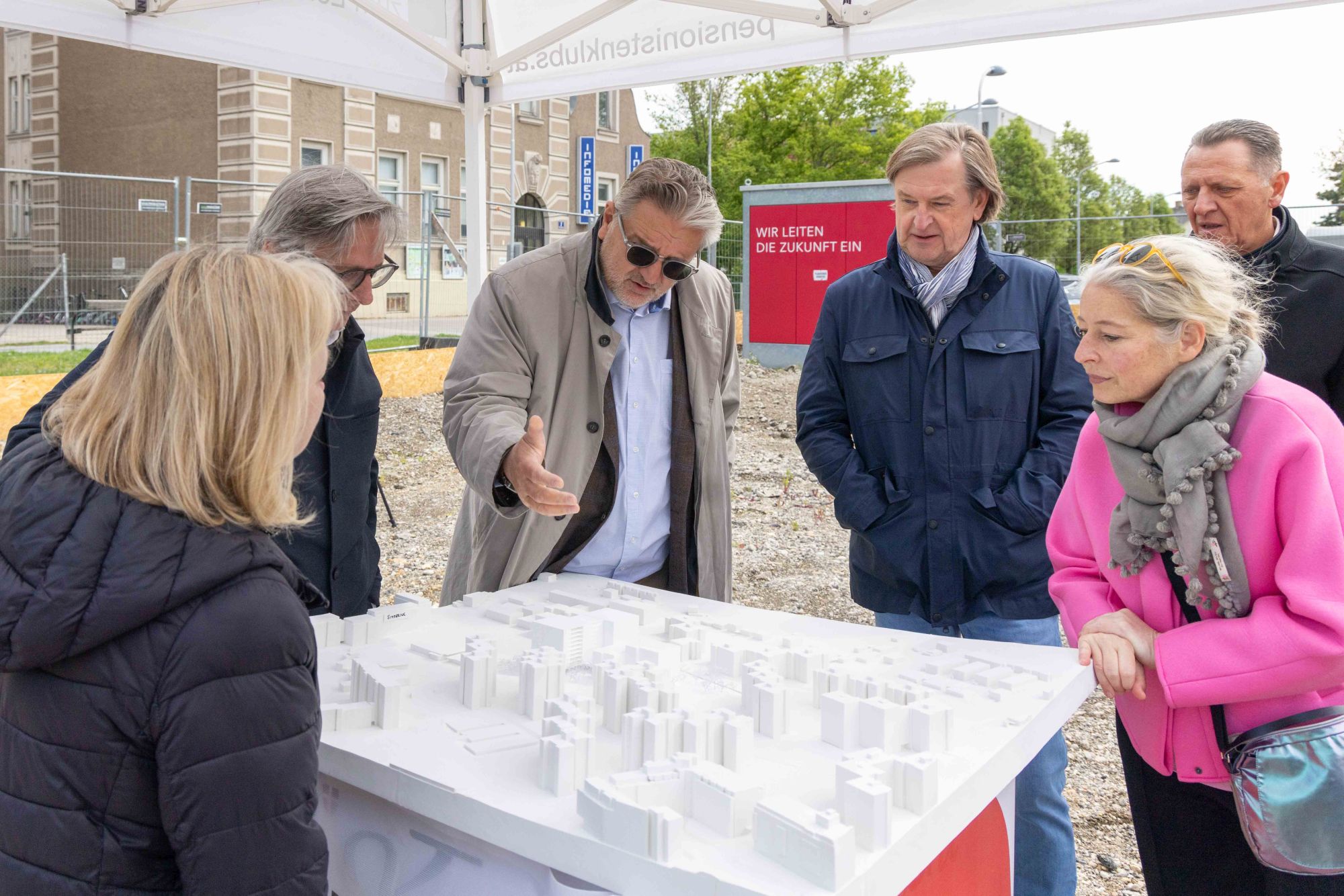 Sozialstadtrat Peter Hacker zeigt anderen Personen etwas auf einem 3-D-Modell für das Haus Haidehofe.