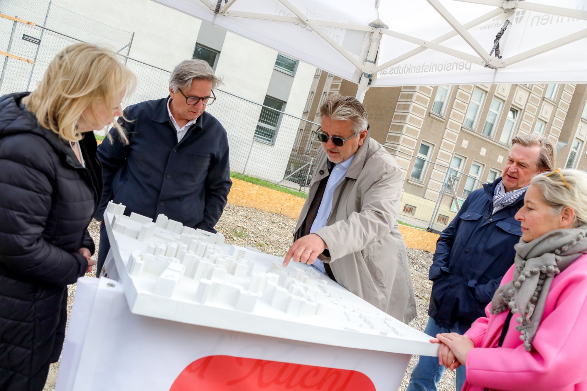 Sozialstadtrat Peter Hacker zeigt anderen Personen etwas auf einem 3-D-Modell für das Haus Haidehofe.