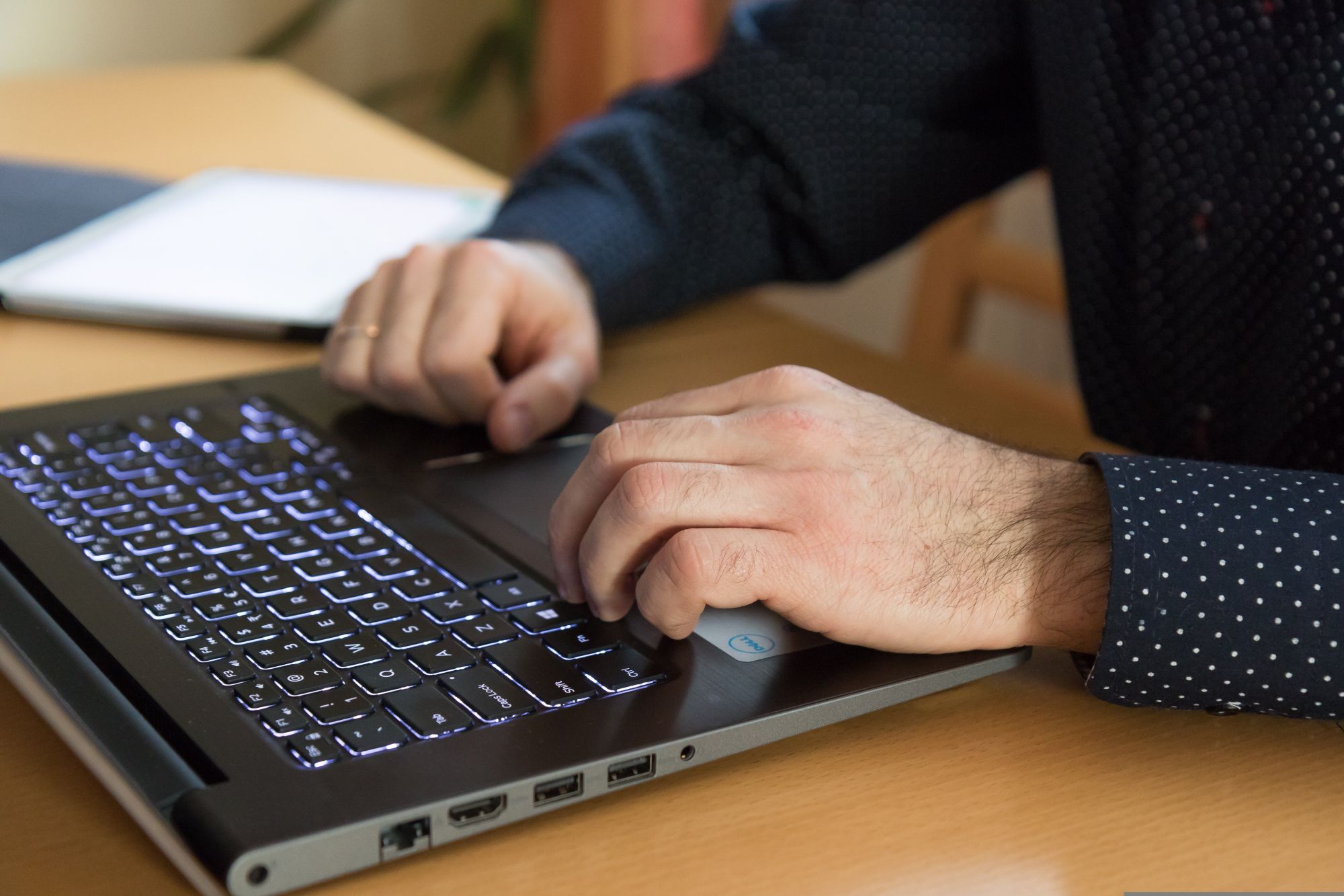 Zwei männliche Hände an einer Laptop-Tastatur.