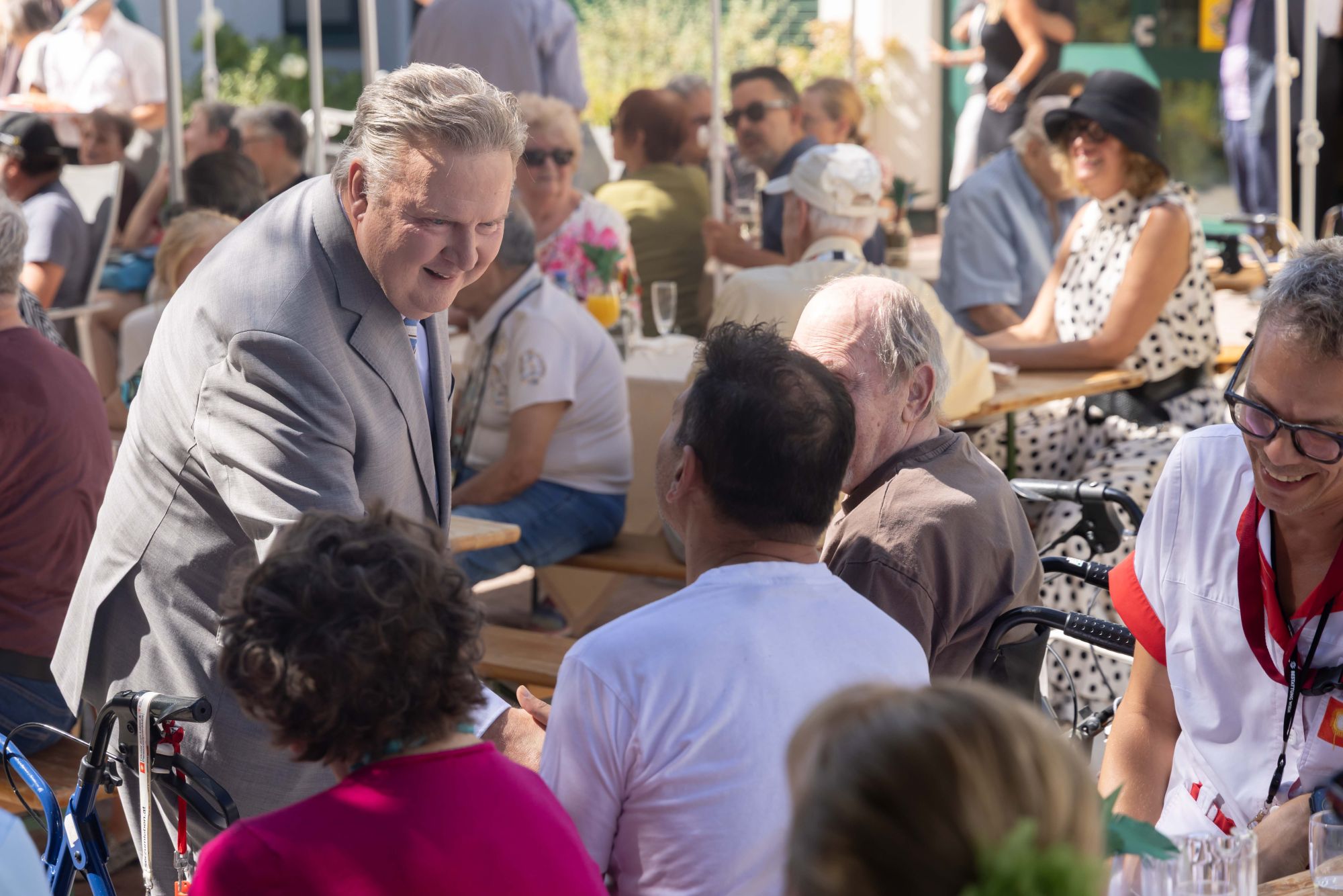 Wiens Bürgermeister Michael Ludwig schüttelt Hände beim Gartenkonzert von Kultursommer Wien im Garten des Hauses Hohe Warte.
