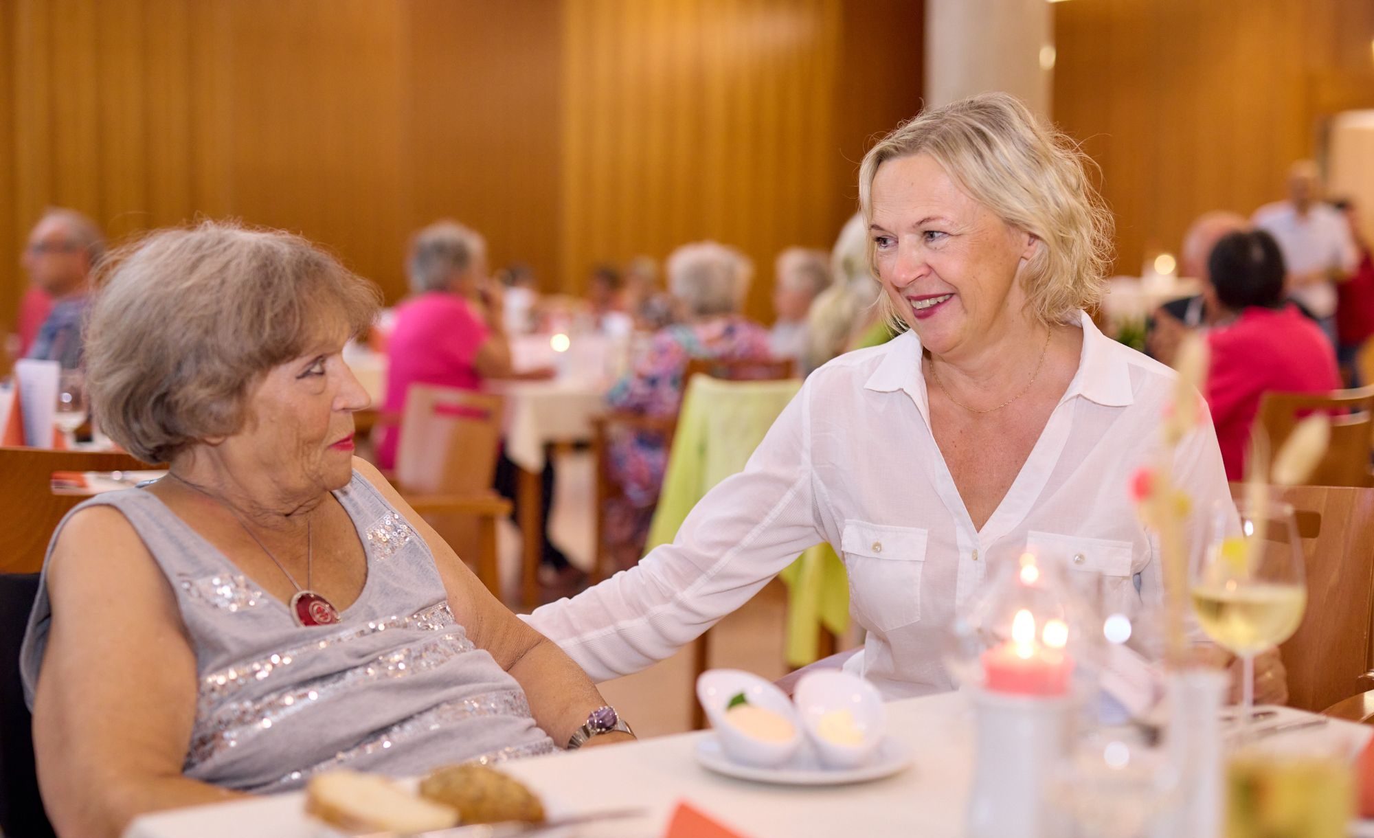 Eine Seniorin und ihre Angehörige an einem Tisch im Demenz-Restaurant "Zum Augenblick".