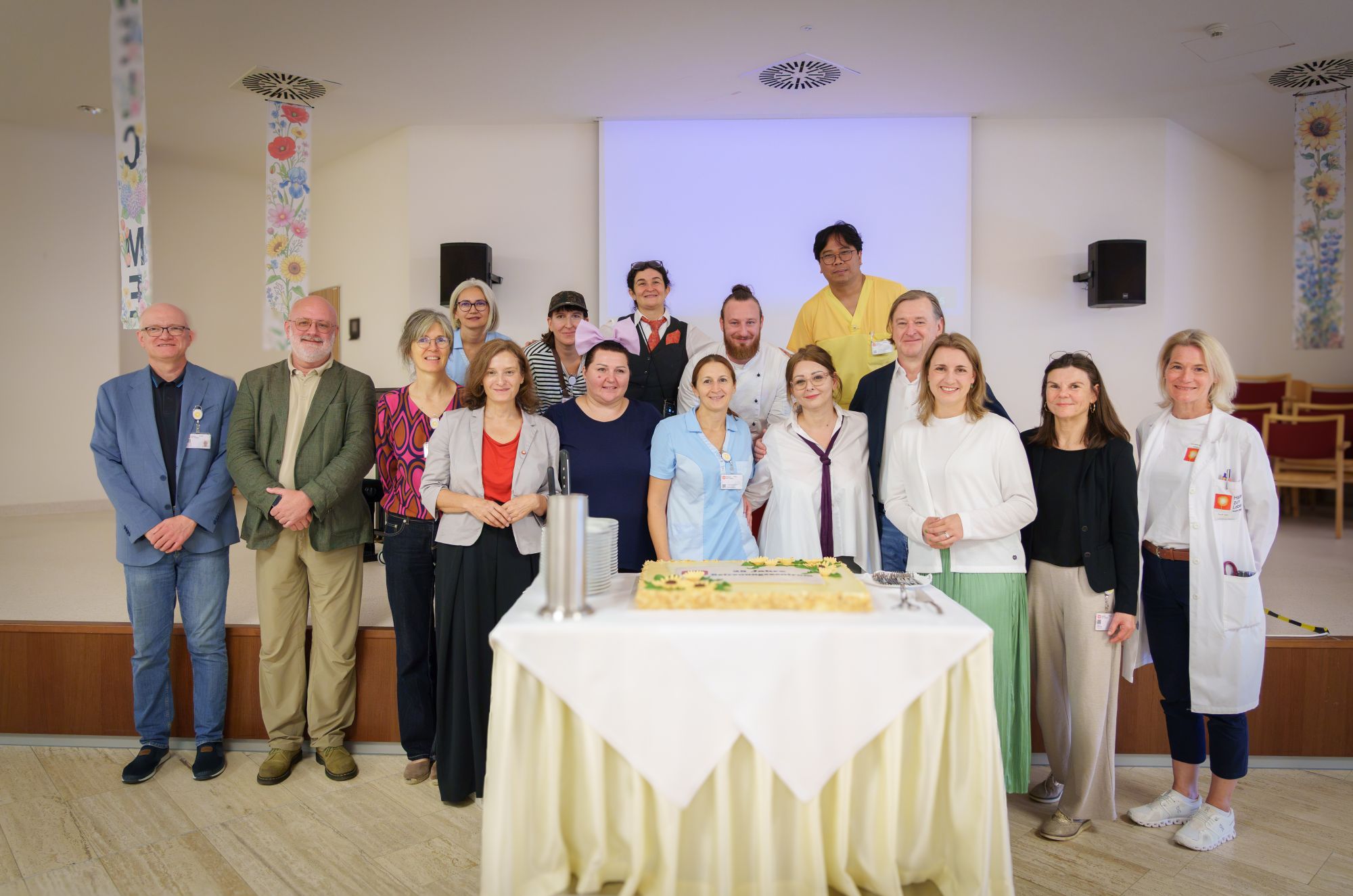 Gruppenbild mit mehreren Personen u.a. aus Haus Rosenberg, Häuser zum Leben mit einer Torte anlässlich "25 Jahre Betreuungszentrum Rosenberg"