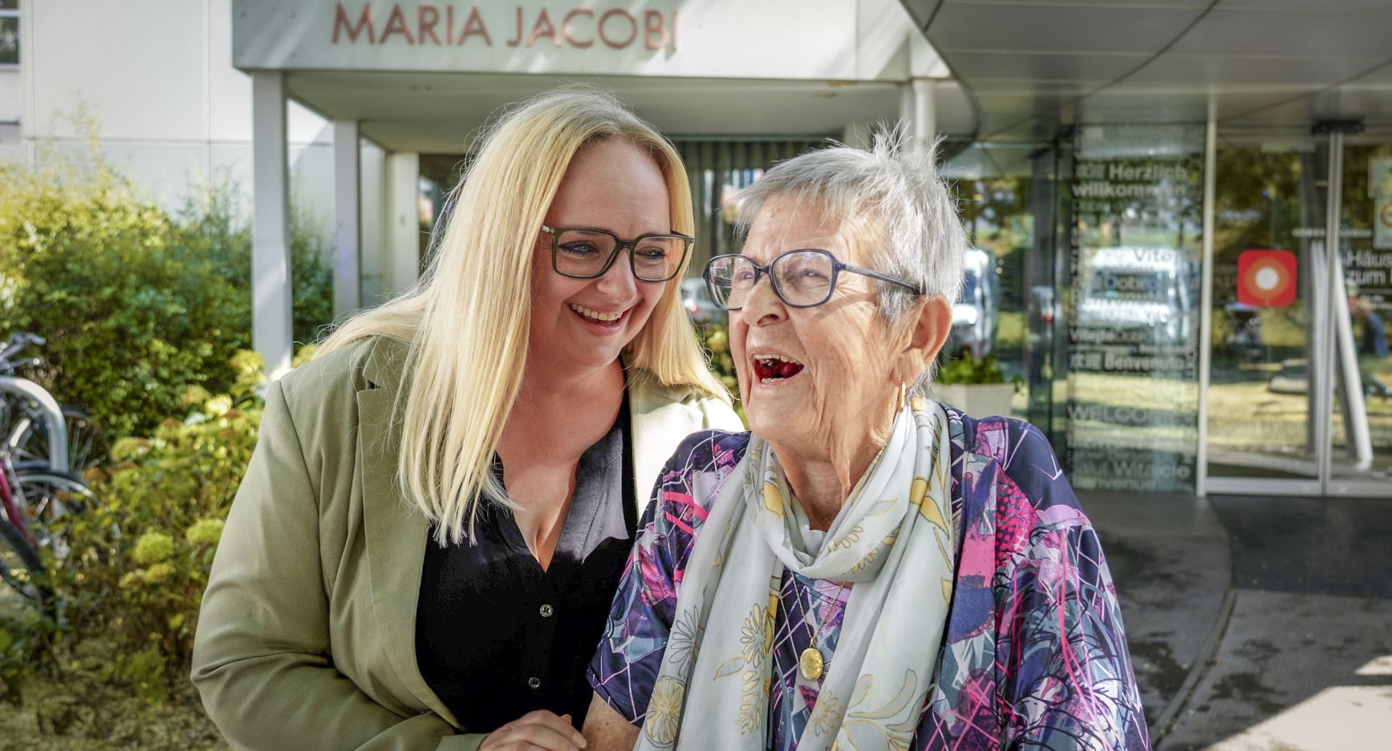 Mitarbeiterin Deborah und Bewohnerin Maria vor dem Haus Maria Jacobi